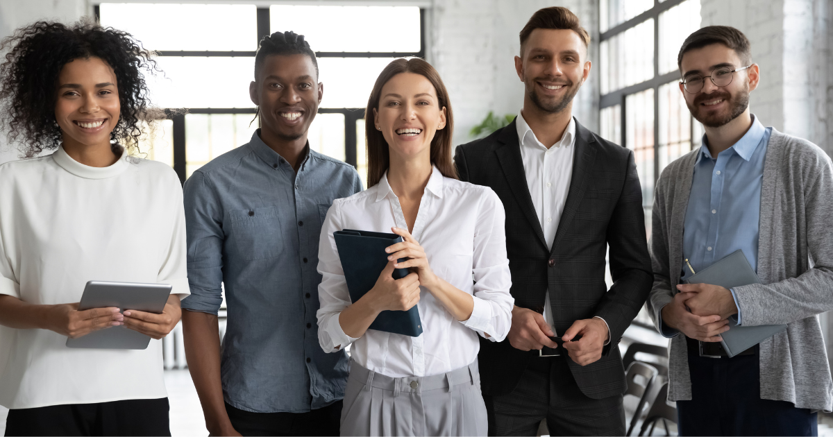 A diverse team of individuals in an office standing together